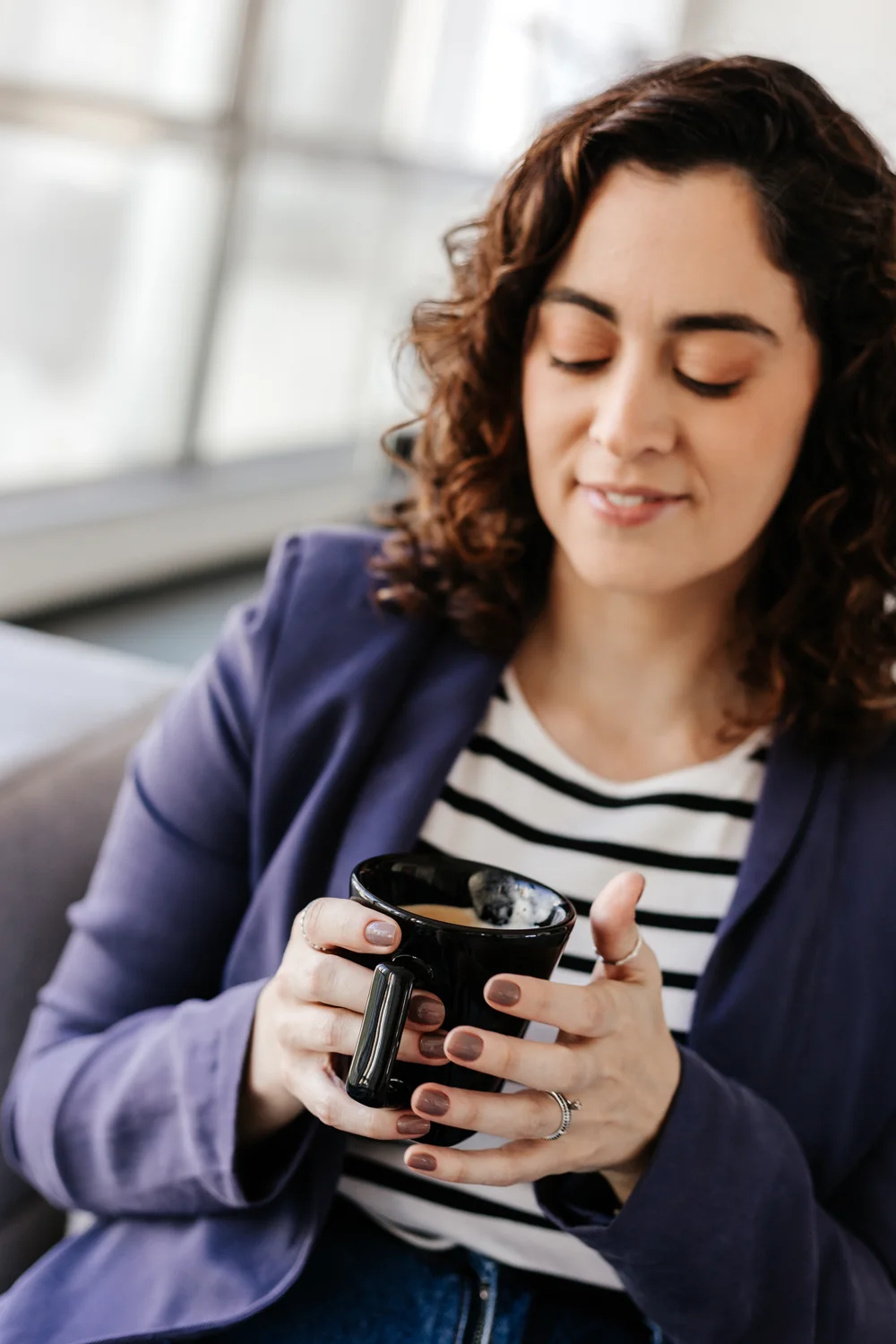 Carol Loiacono in a blue blazer, holding a mug.